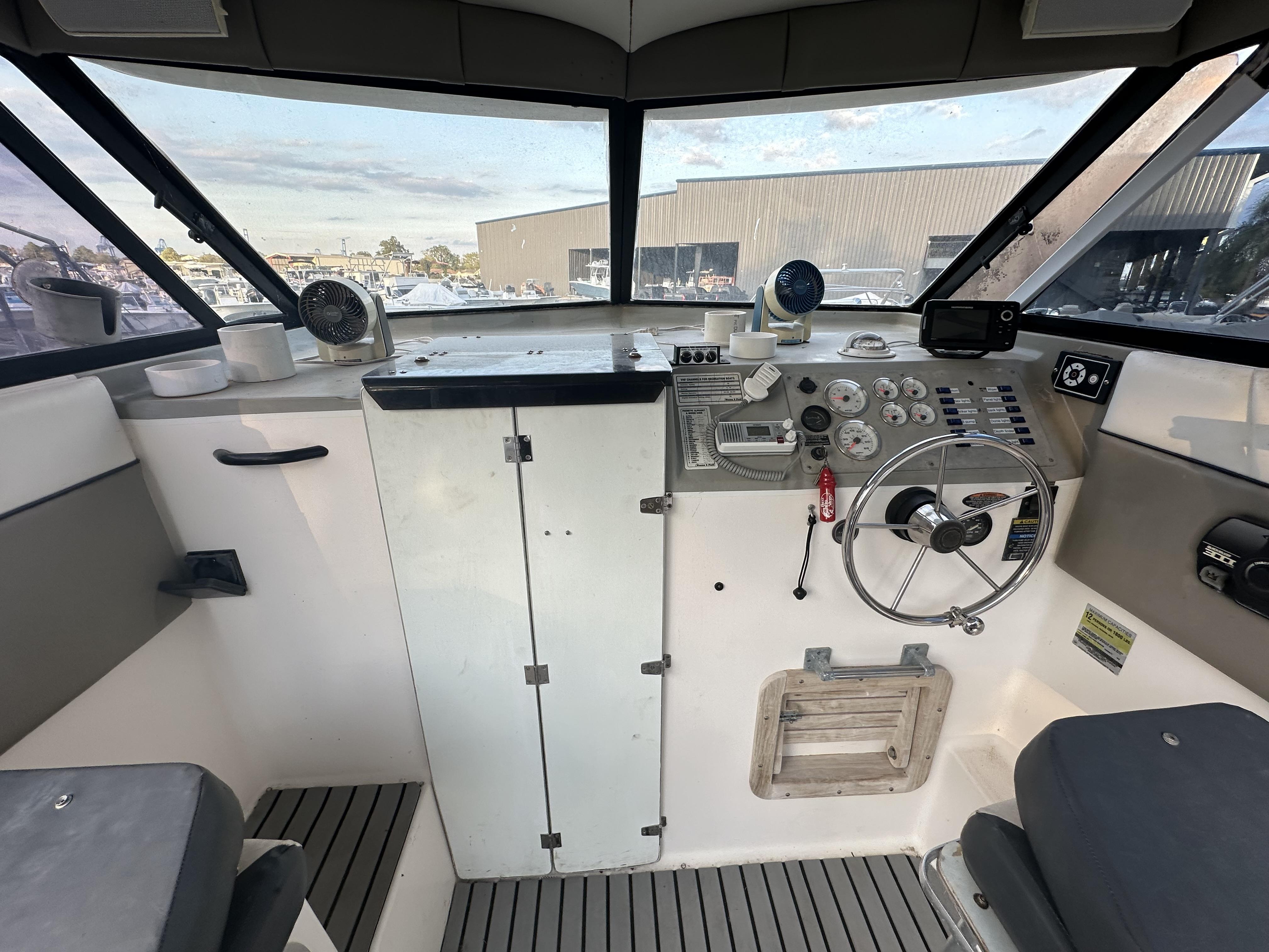 Slide: The Image of 1998 Bayliner 2452 Ciera Express helm with steering wheel, gauges, and controls. - 15
