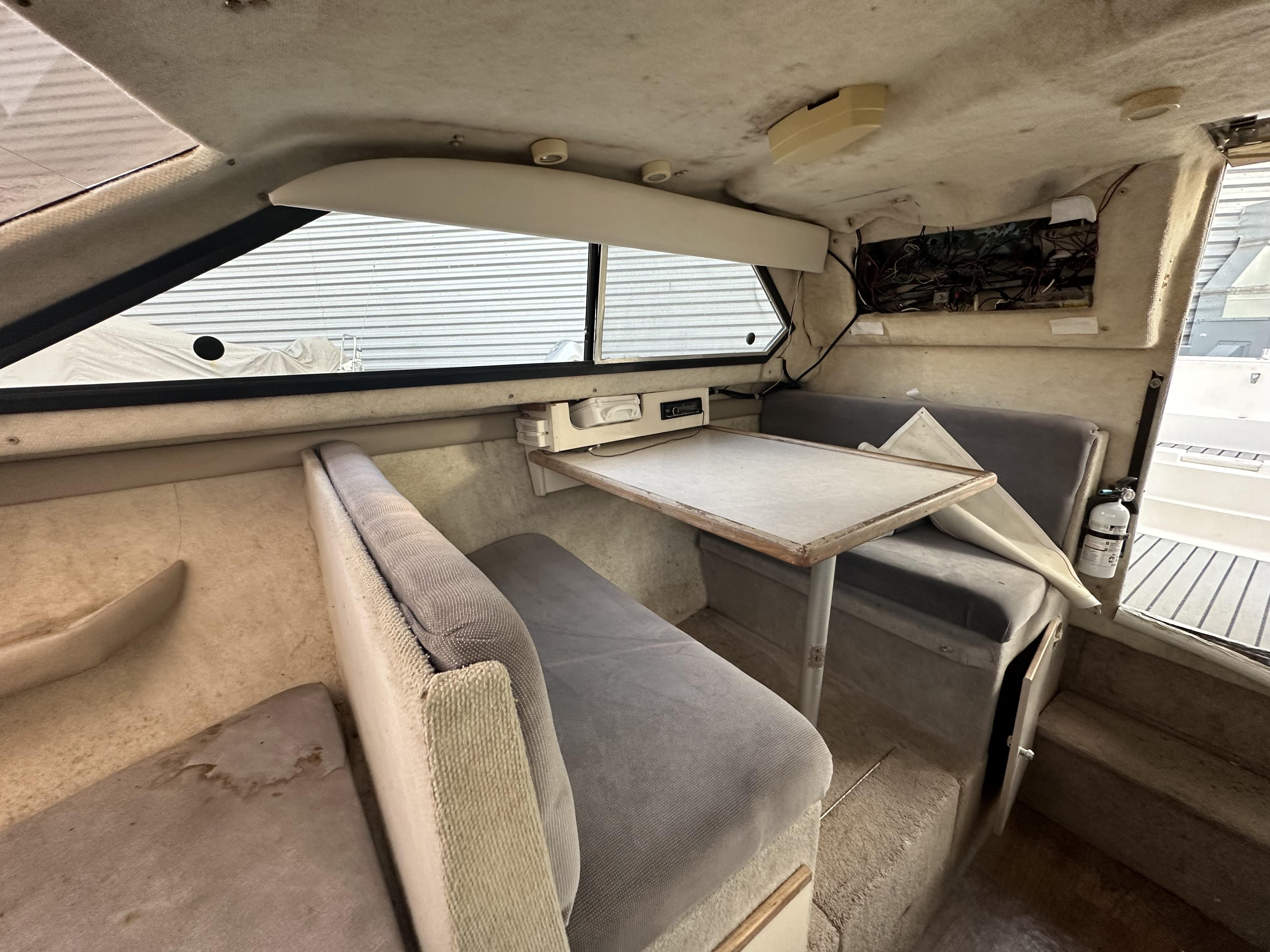 Slide: The Image of Interior of a 1998 Bayliner 2452 Ciera Express with seating and table. - 16