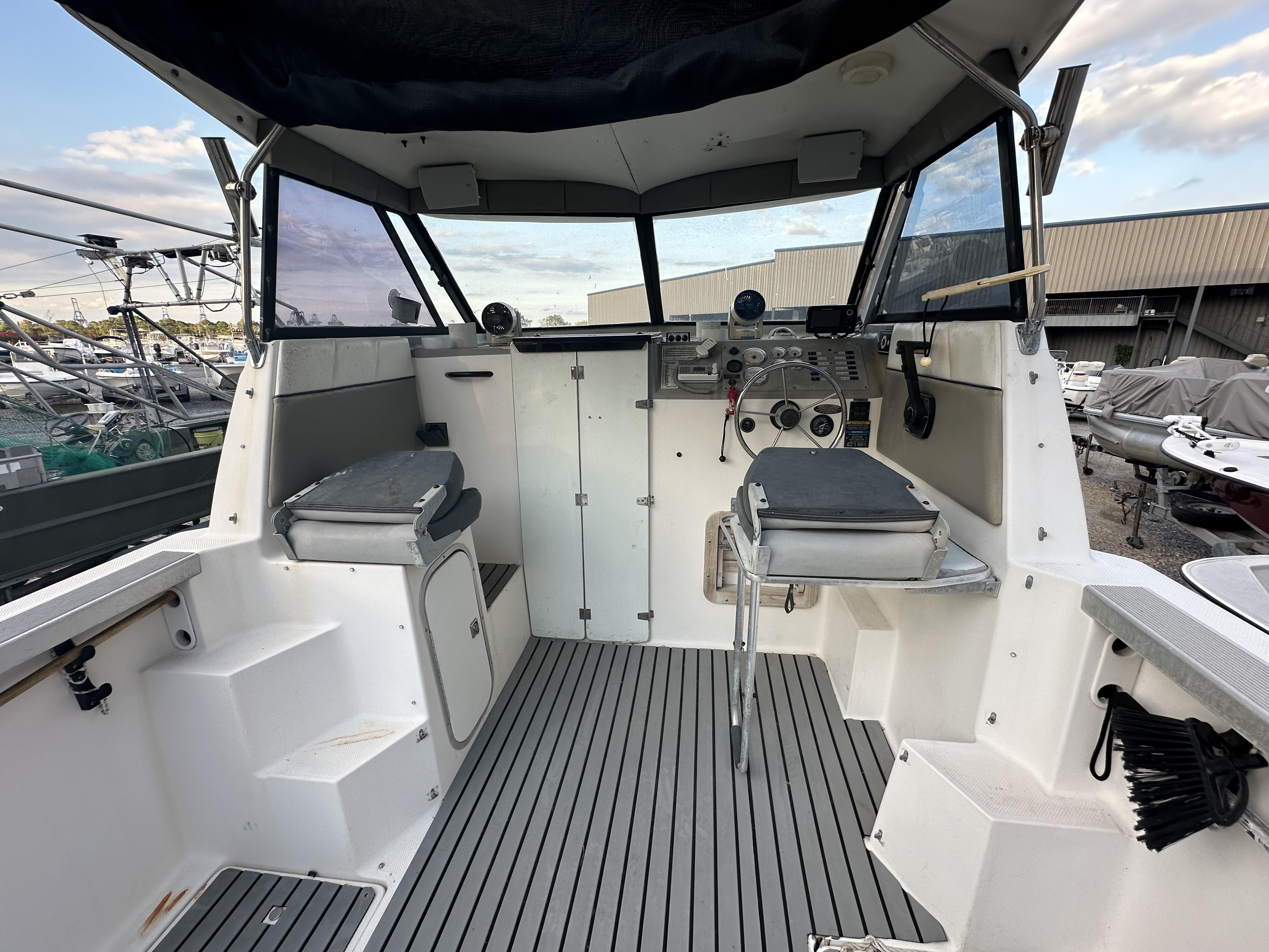 Slide: The Image of 1998 Bayliner 2452 Ciera Express boat interior with helm, seating, and controls. - 3