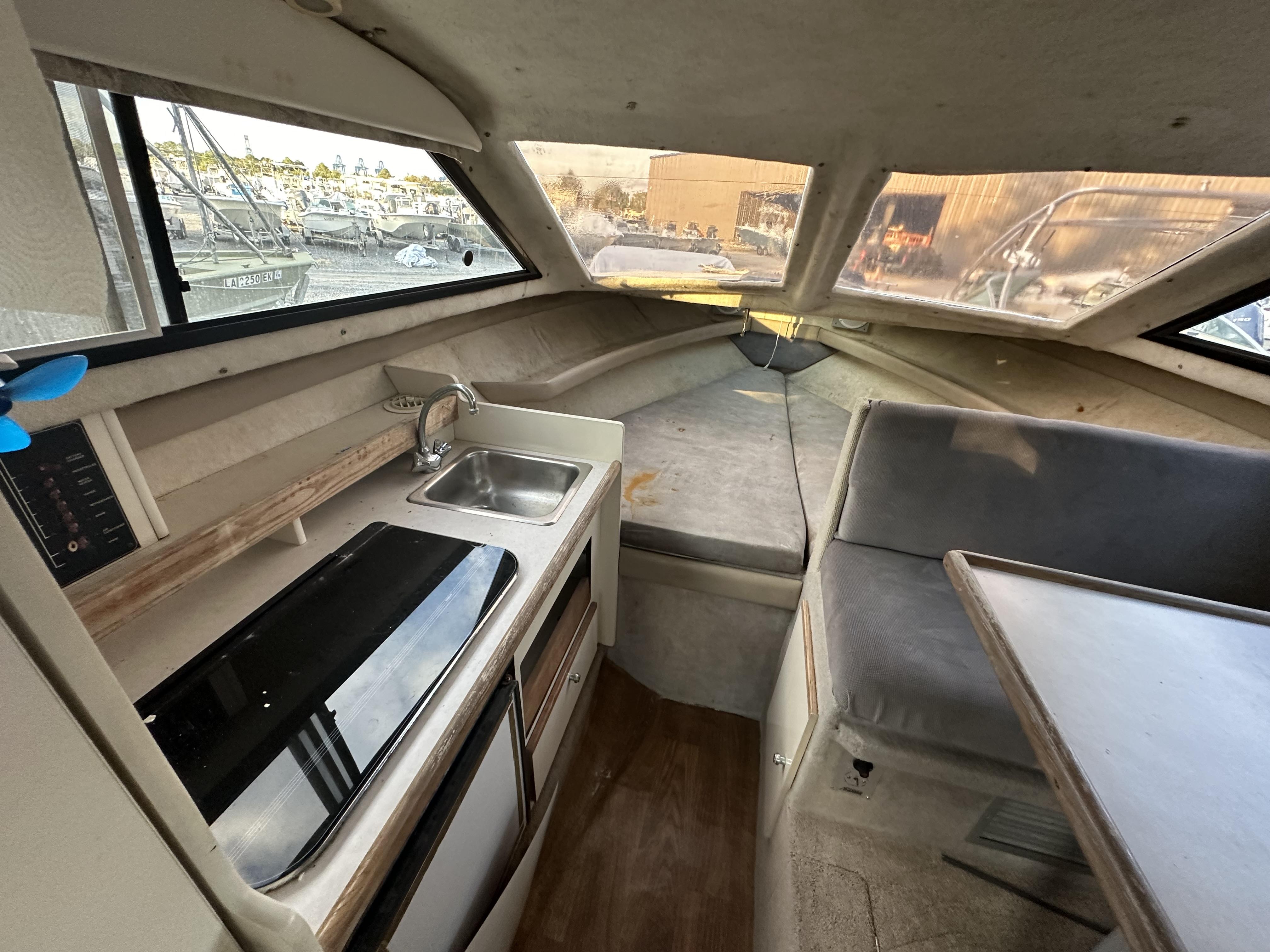 Slide: The Image of Interior of 1998 Bayliner 2452 Ciera Express, featuring kitchenette and seating area. - 4