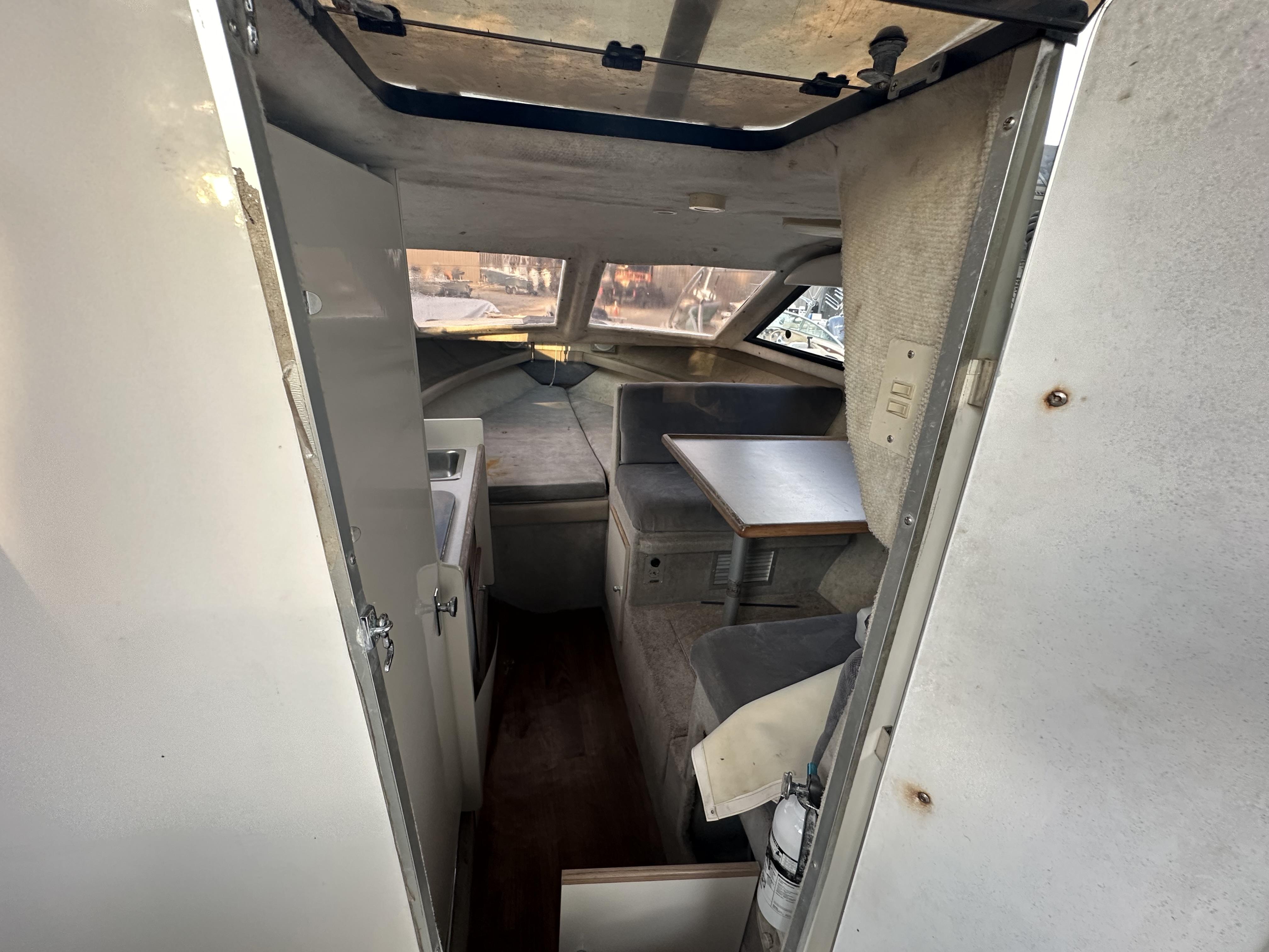 Slide: The Image of Interior of 1998 Bayliner 2452 Ciera Express boat, featuring seating and table. - 5