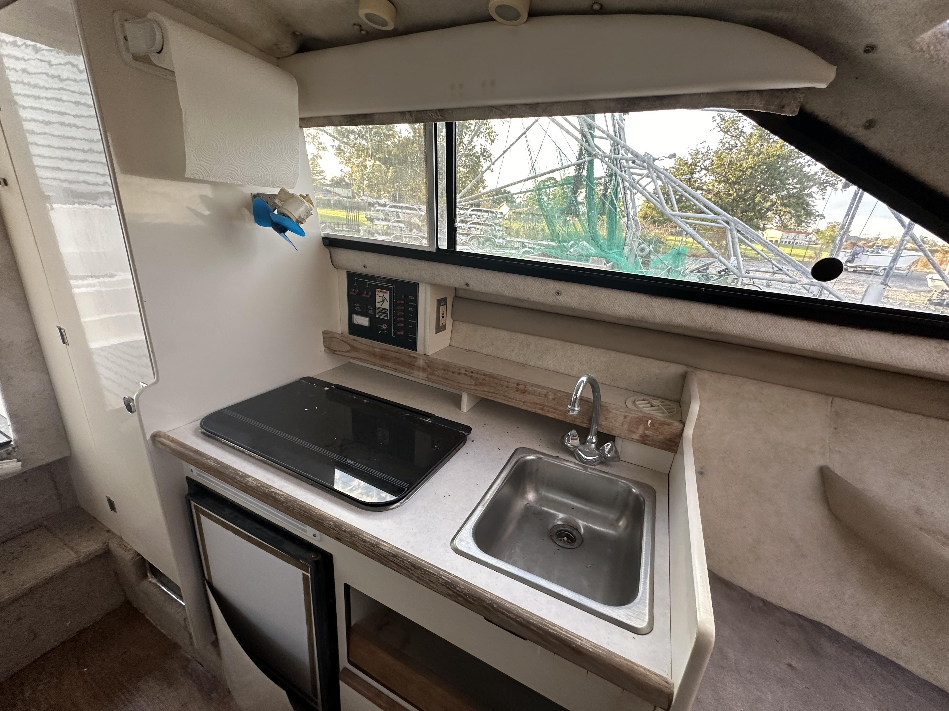 Slide: The Image of 1998 Bayliner 2452 Ciera Express boat interior with kitchenette, sink, and window view. - 8