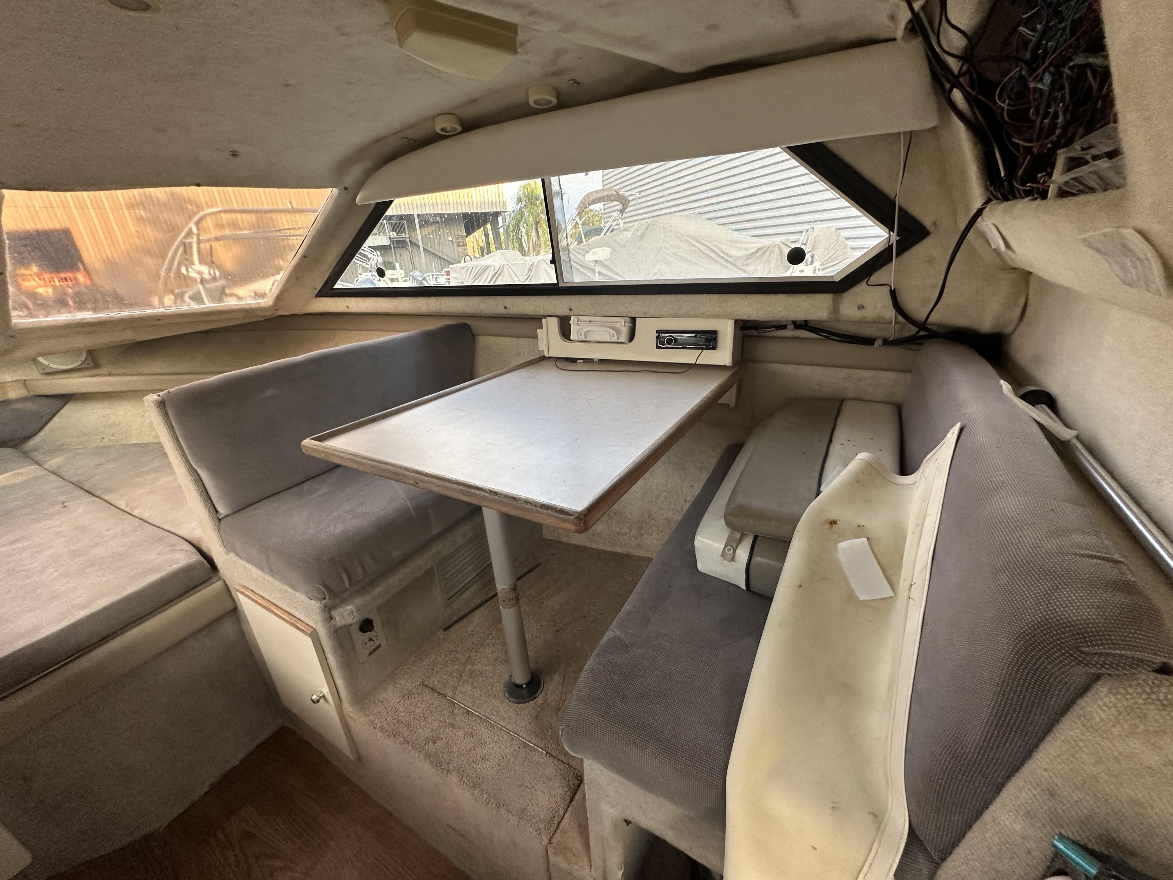 Slide: The Image of Interior of a 1998 Bayliner 2452 Ciera Express boat with seating and table. - 9
