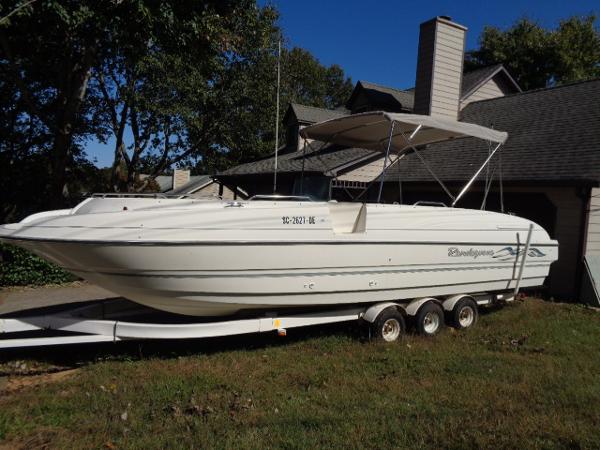 Slide: The Image of 1998 Bayliner 2659 Rendezvous boat on a trailer in front of a house. - 0