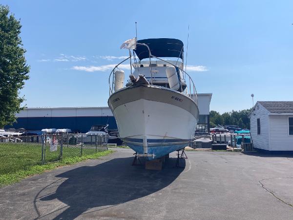 Slide: The Image of 1984 Bayliner 3270 Command Bridge boat on dry dock in marina. - 1