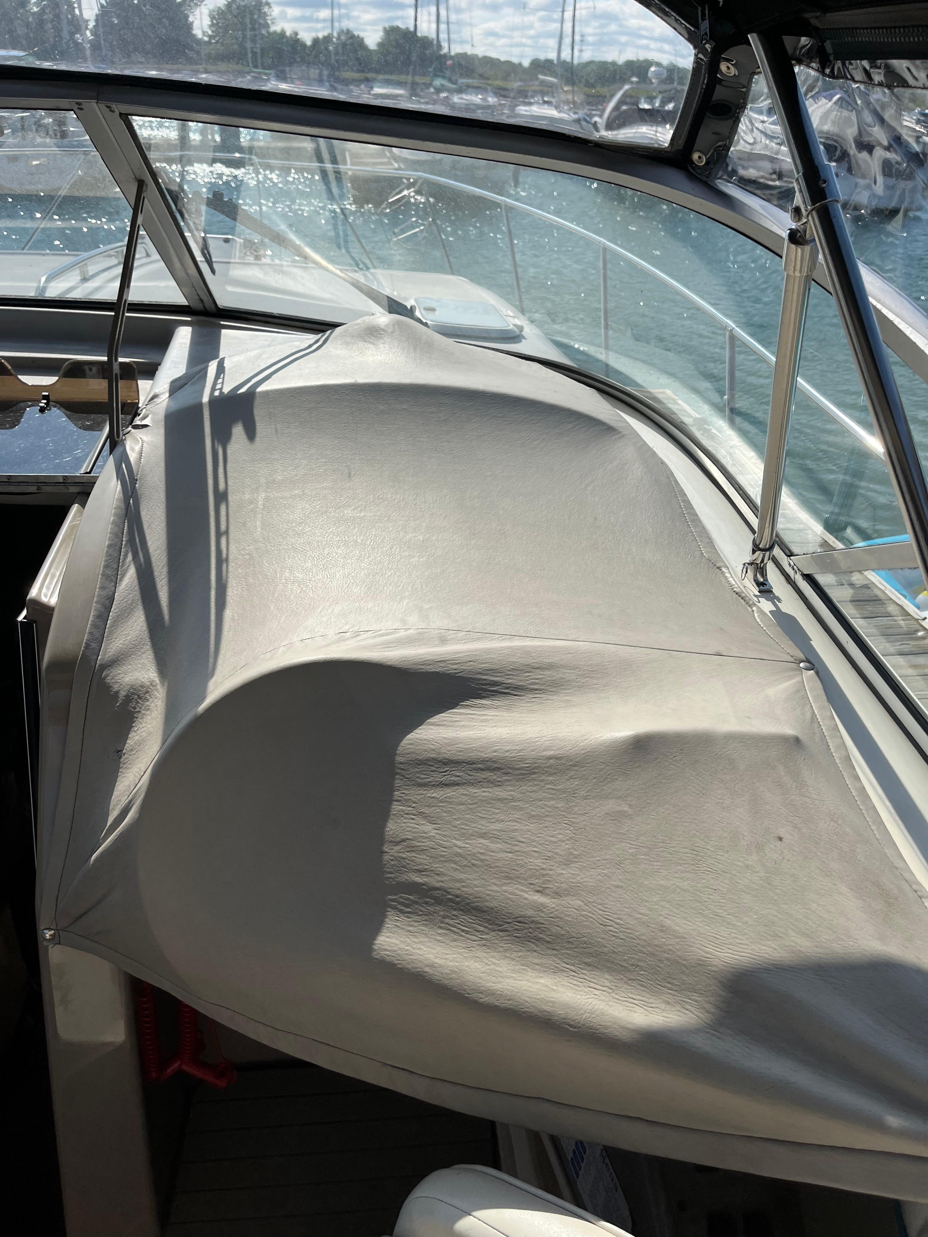 Slide: The Image of 1996 Bayliner 32 Avante boat interior with covered dashboard and marina view. - 10
