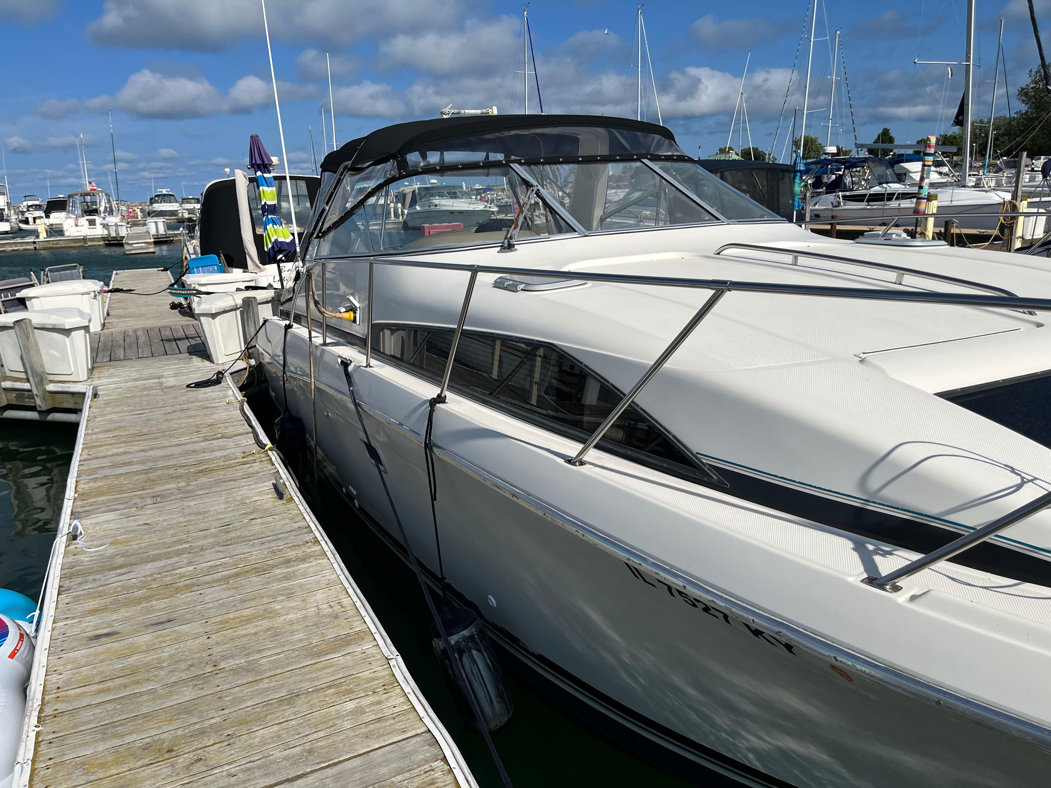 Slide: The Image of 1996 Bayliner 32 Avante docked at a marina on a sunny day. - 23