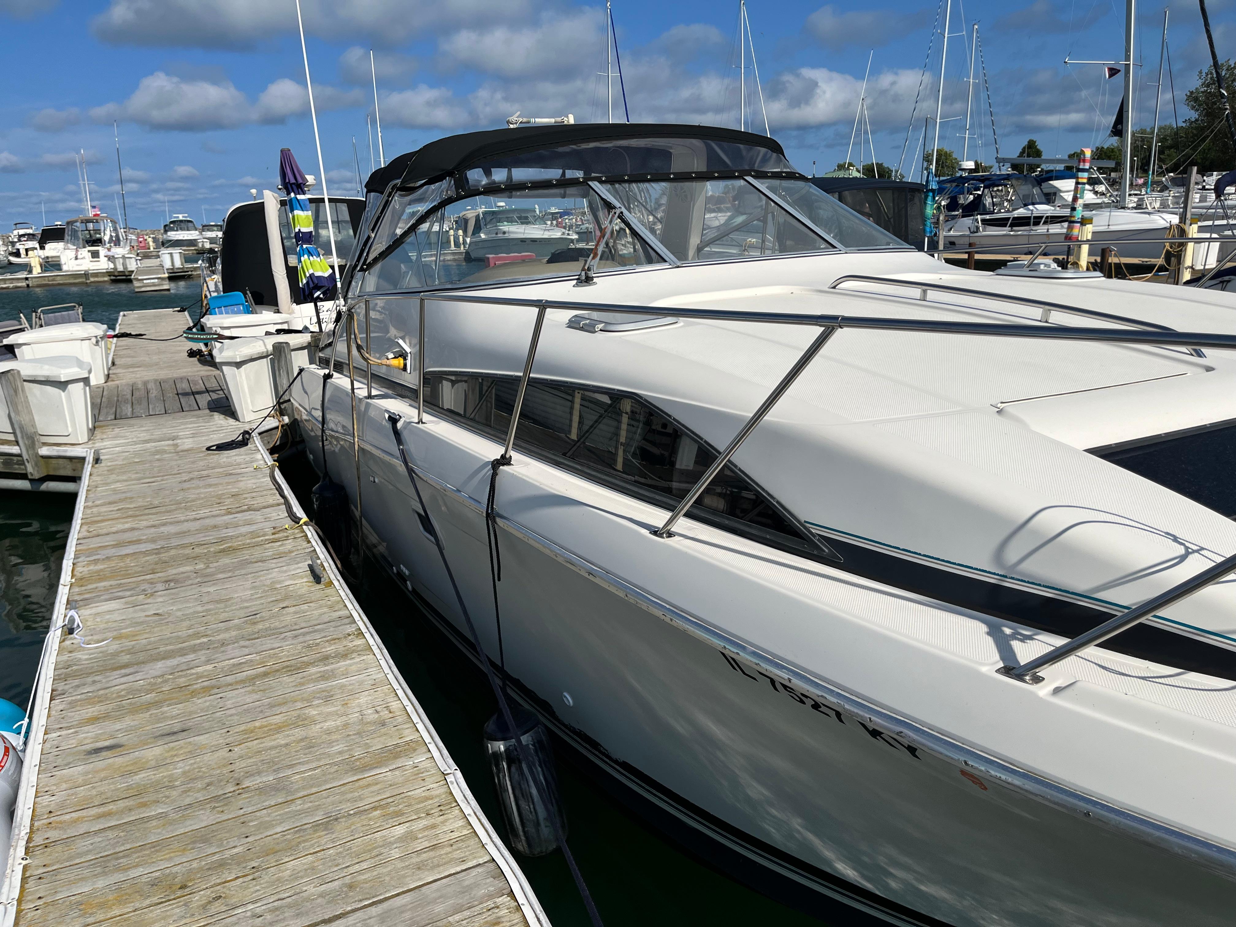 Slide: The Image of 1996 Bayliner 32 Avante docked at a marina on a sunny day. - 24
