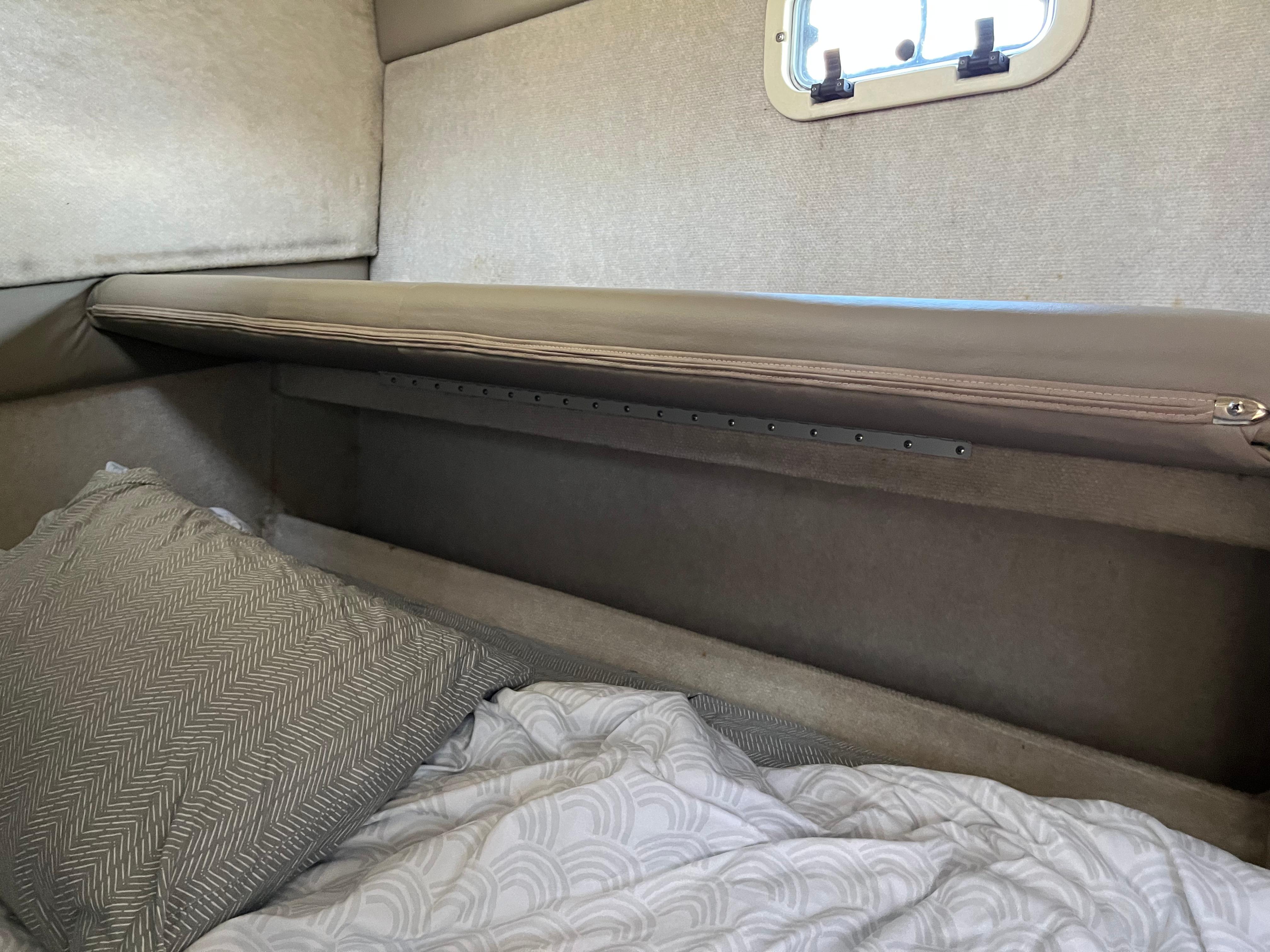 Slide: The Image of Interior cabin of a 1996 Bayliner 32 Avante boat with bedding and a small window. - 32