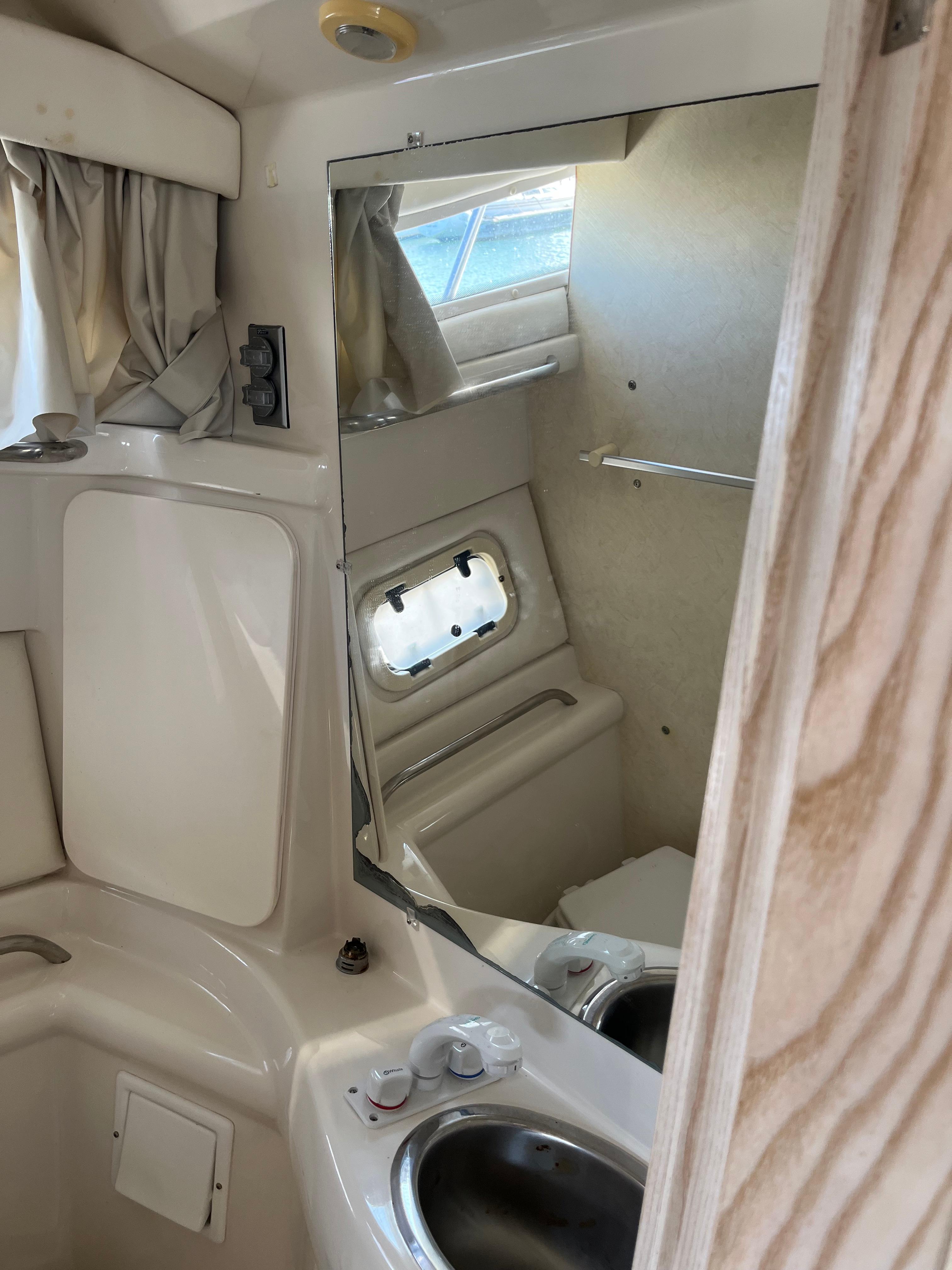 Slide: The Image of 1996 Bayliner 32 Avante boat bathroom with sink, mirror, and window. - 34
