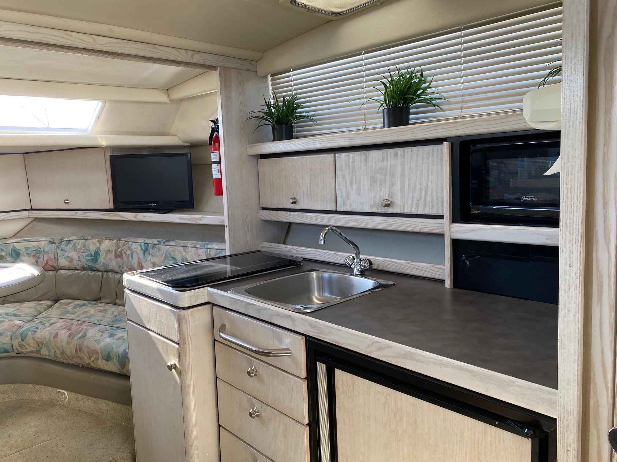 Slide: The Image of 1996 Bayliner 32 Avante interior with kitchenette, seating area, and TV. - 41