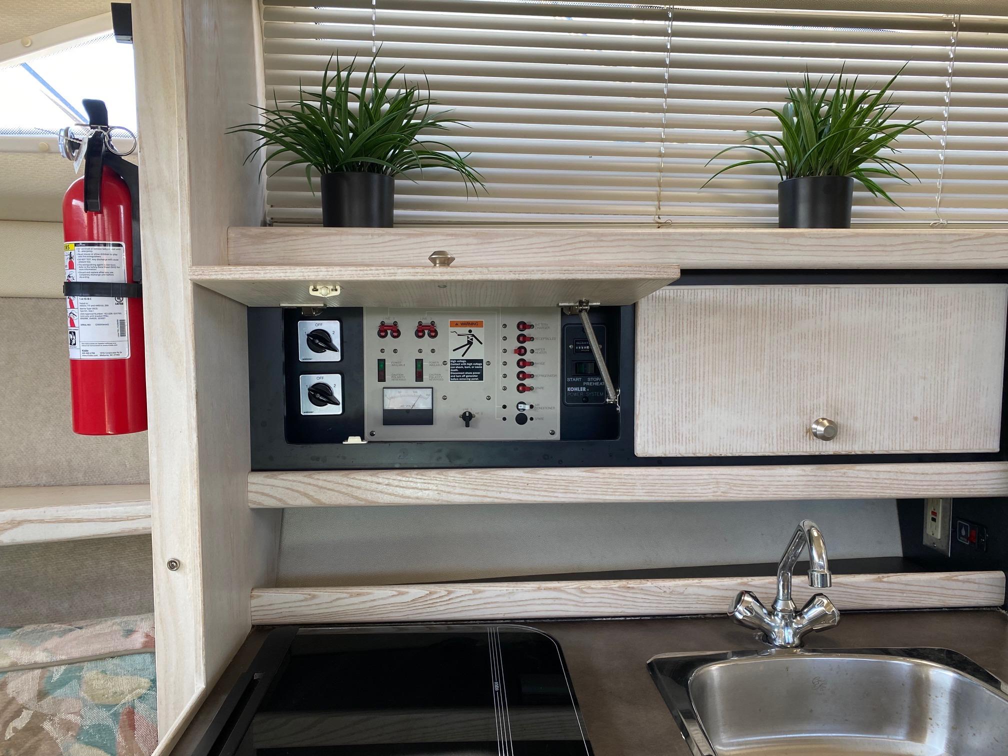 Slide: The Image of 1996 Bayliner 32 Avante kitchen area with control panel, sink, and fire extinguisher. - 44