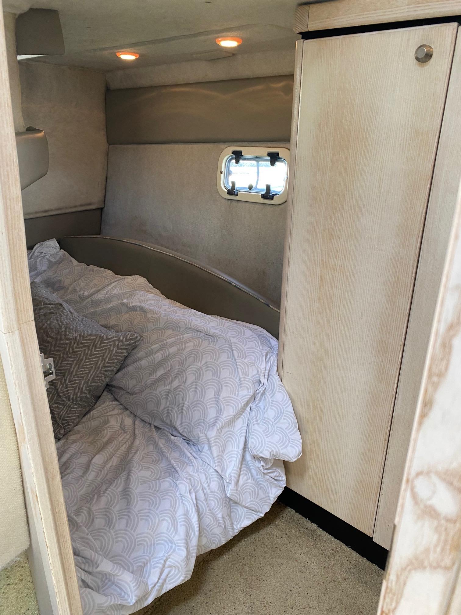Slide: The Image of Cozy cabin bedroom in a 1996 Bayliner 32 Avante boat with soft lighting. - 49