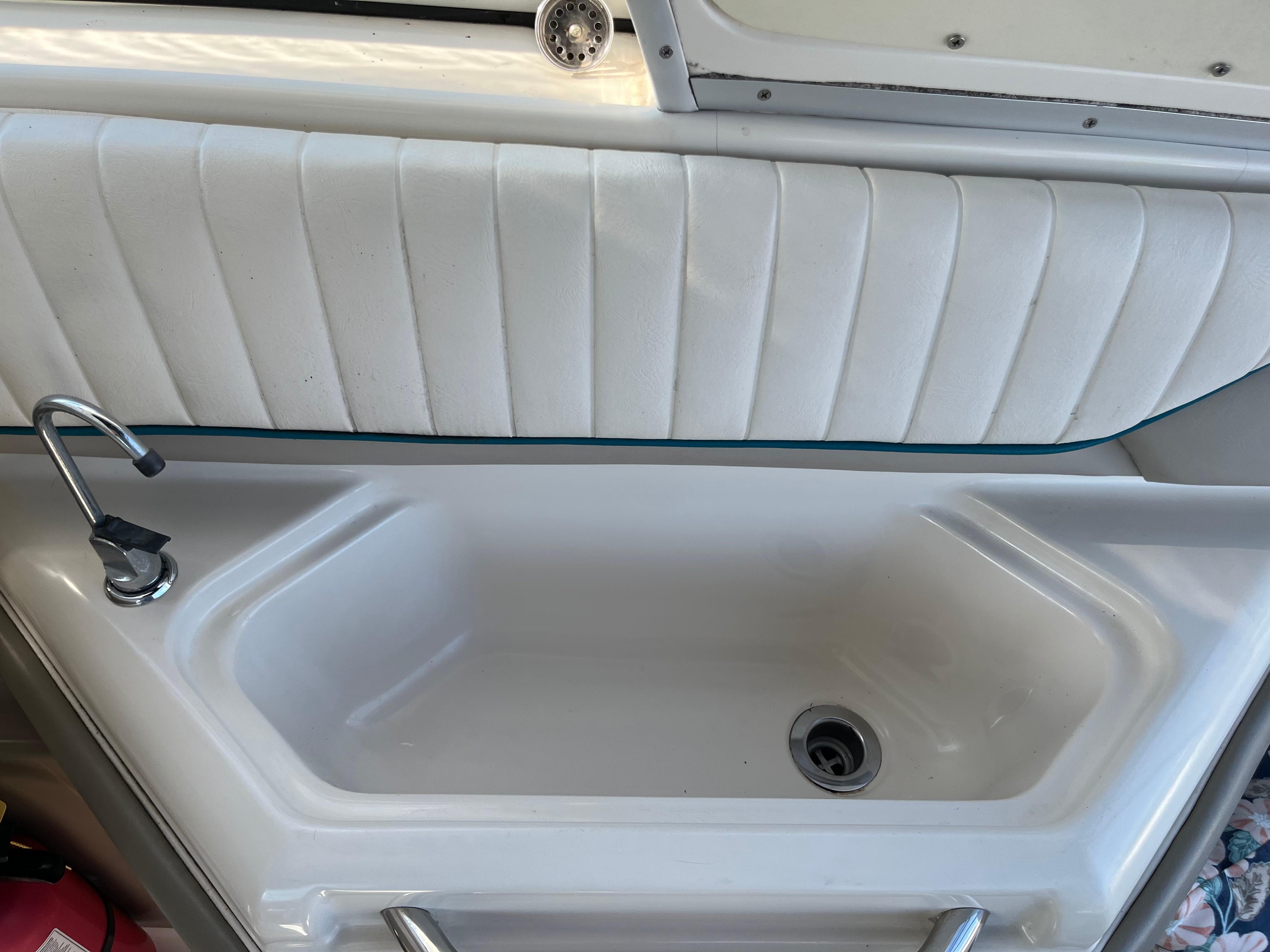 Slide: The Image of 1996 Bayliner 32 Avante boat sink with faucet and white padded paneling. - 8