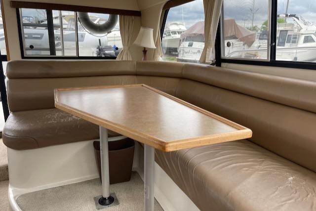 Slide: The Image of Interior seating area of a 2000 Bayliner 3388 yacht with a wooden table. - 10
