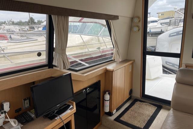 Slide: The Image of Interior of 2000 Bayliner 3388 yacht with TV, window view, and door to deck. - 12
