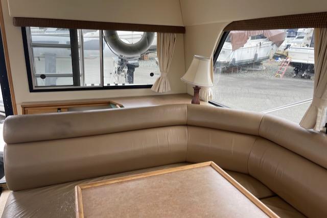 Slide: The Image of Interior of 2000 Bayliner 3388 yacht with beige leather seating and table. - 13