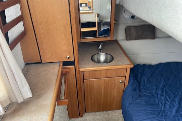 Slide: The Image of 2000 Bayliner 3388 cabin interior with sink, storage, and bed. - 14