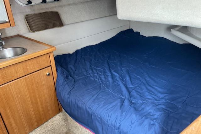 Slide: The Image of Bayliner 3388 2000 model cabin with bed, sink, and storage cabinet. - 15