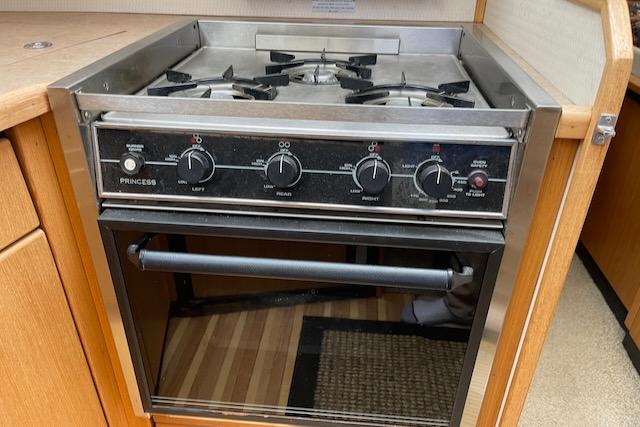 Slide: The Image of Bayliner 3388 2000 model kitchen stove and oven with wooden cabinetry. - 19
