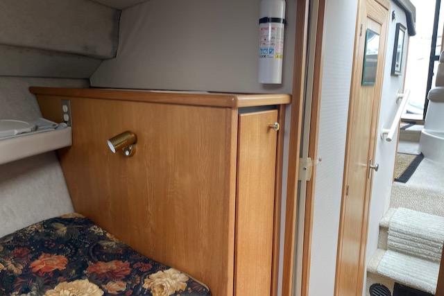 Slide: The Image of Interior cabin of a 2000 Bayliner 3388 boat with wood paneling and floral bedding. - 27