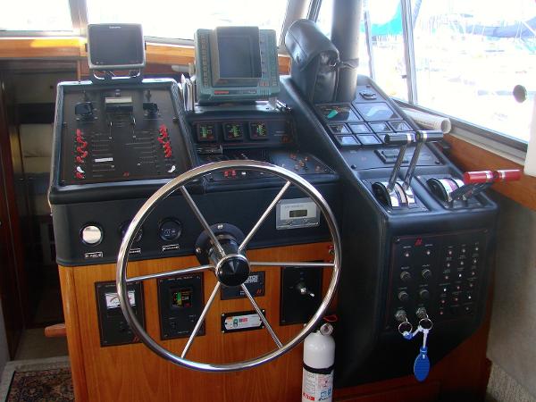 Slide: The Image of 1987 Bayliner 3888 Motoryacht helm with steering wheel, controls, and navigation equipment. - 4