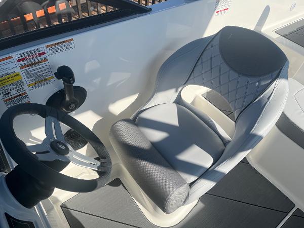 Slide: The Image of 2024 Bayliner DX2000 boat cockpit with steering wheel and captain's chair. - 11