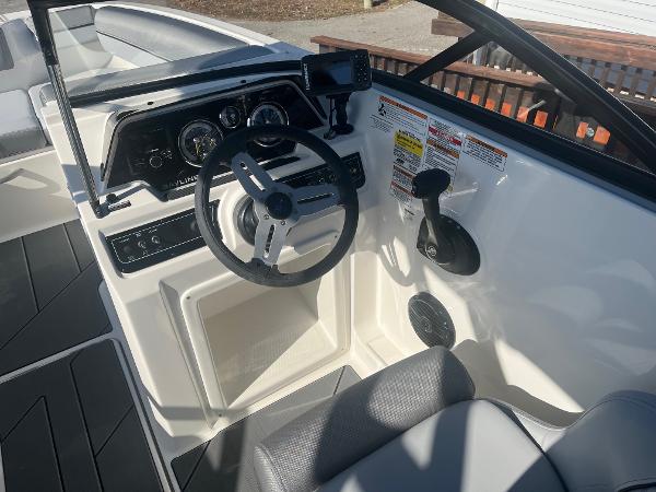 Slide: The Image of 2024 Bayliner DX2000 boat cockpit with steering wheel and control panel. - 7