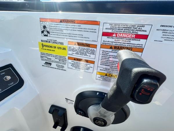 Slide: The Image of Bayliner DX 2050 2023 boat control panel with safety warnings and capacity limits. - 19