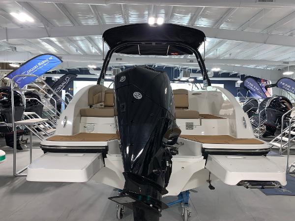 Slide: The Image of 2024 Bayliner DX2200 boat with outboard motor in showroom. - 2