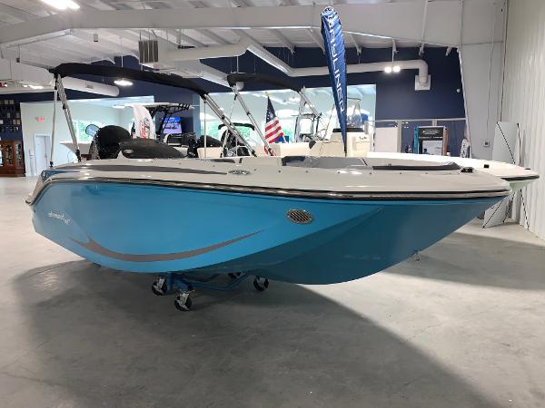 Slide: The Image of 2024 Bayliner Element M17 boat in showroom, blue hull, bimini top. - 2