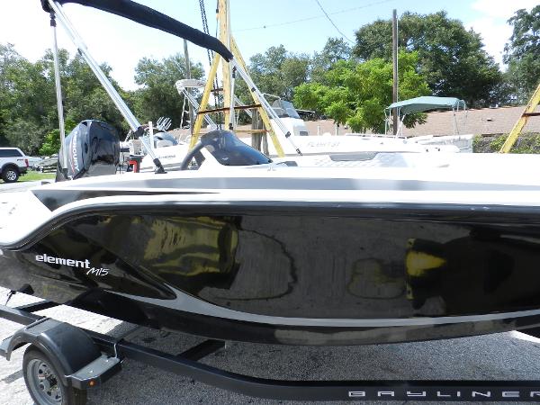 Slide: The Image of 2025 Bayliner M15 boat on trailer, sleek black design, outdoor setting. - 0