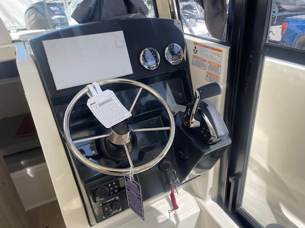 Slide: The Image of 2024 Bayliner Trophy 23 Pilothouse helm with steering wheel and controls. - 12