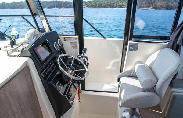 Slide: The Image of 2024 Bayliner Trophy 23 Pilothouse interior with steering wheel and captain's chair. - 14
