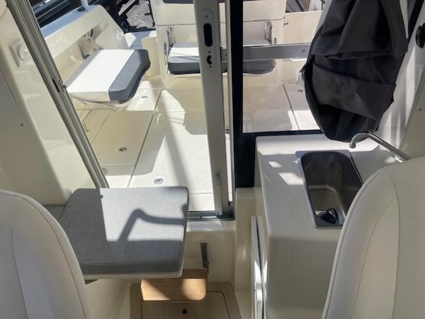 Slide: The Image of 2024 Bayliner Trophy 23 Pilothouse interior with seating and sink. - 16