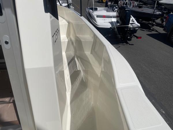 Slide: The Image of 2024 Bayliner Trophy 23 Pilothouse boat exterior view at a marina. - 19