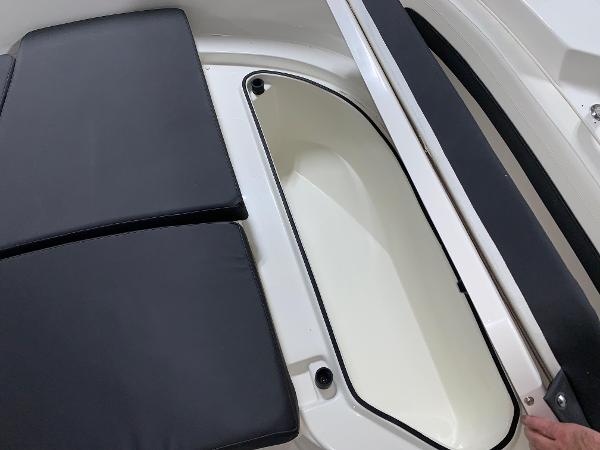 Slide: The Image of Bayliner Trophy 24 CC 2024 boat storage compartment with black cushioned seating. - 3