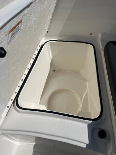 Slide: The Image of 2023 Bayliner Trophy T24 boat storage compartment, white interior, open lid. - 6