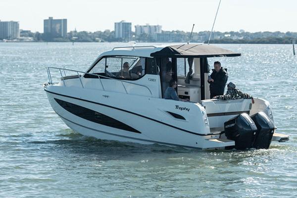 Slide: The Image of 2024 Bayliner Trophy T29EX boat cruising on a sunny day. - 2