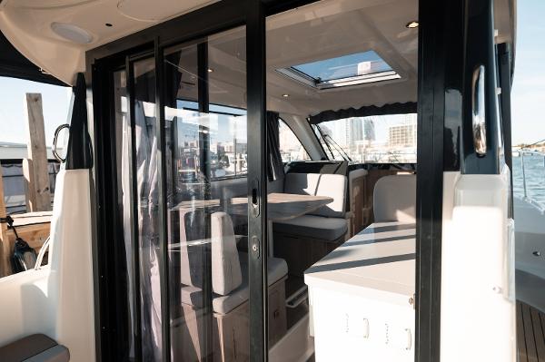 Slide: The Image of 2024 Bayliner Trophy T29EX interior with modern seating and glass doors. - 6