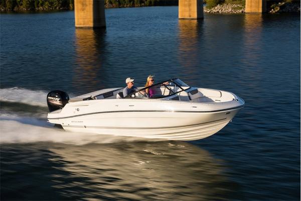 Slide: The Image of 2023 Bayliner VR5 Bowrider speeding on a lake with two passengers. - 10