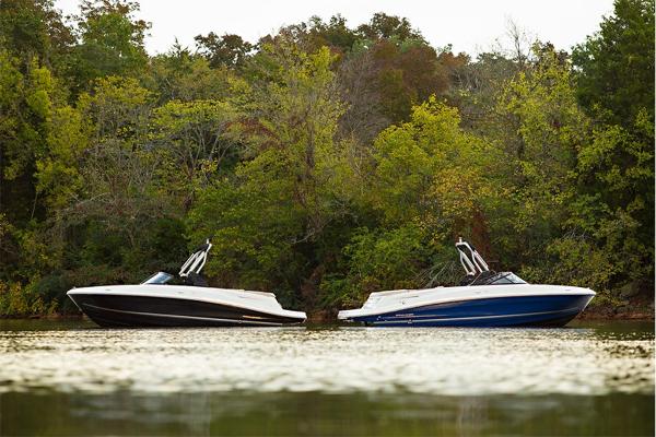 Slide: The Image of 2023 Bayliner VR5 Bowrider boats on a serene lake with lush green trees. - 7