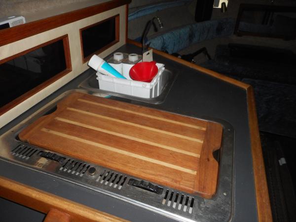 Slide: The Image of 1984 Beachcraft Cabin Cruiser kitchen area with cutting board and sink. - 14