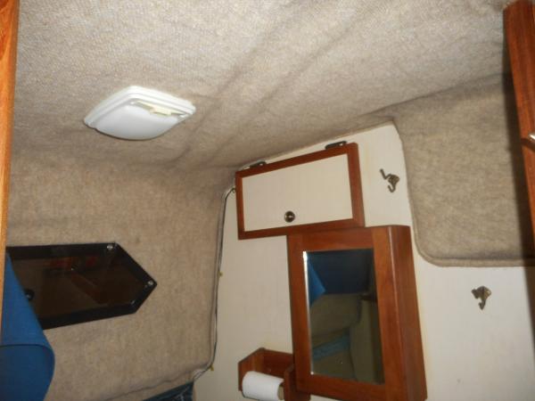 Slide: The Image of Interior of a 1984 Beachcraft Cabin Cruiser with wooden cabinets and a small mirror. - 18