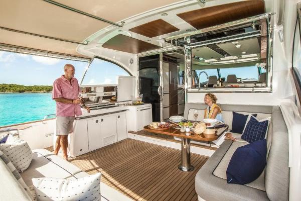 Slide: The Image of 2024 Belize 66 Sedan yacht interior with people dining and relaxing. - 8