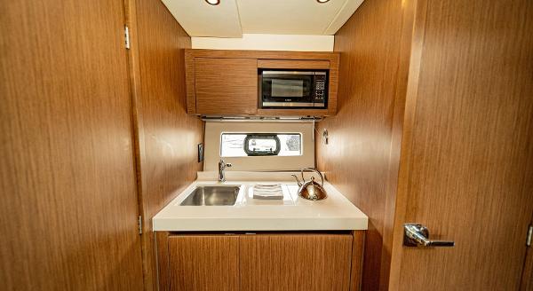 Slide: The Image of Compact kitchen area in 2024 Beneteau 36 Gran Turismo GT yacht with sink and microwave. - 31