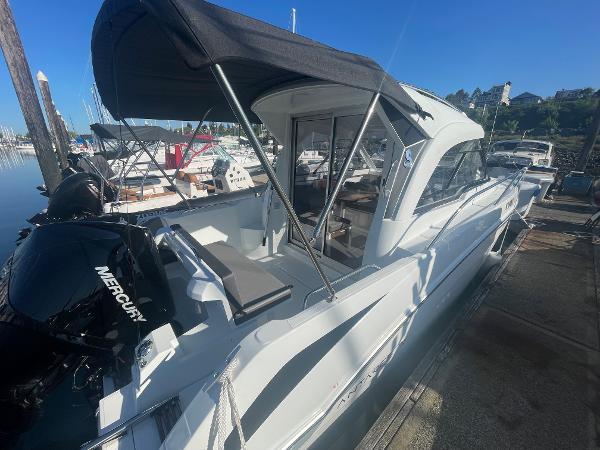 Slide: The Image of 2022 Beneteau Antares 7 boat docked, featuring a Mercury outboard motor. - 1
