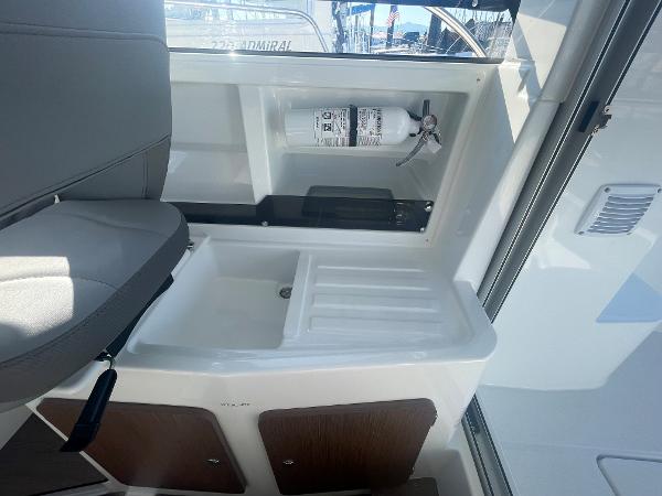 Slide: The Image of Interior of 2022 Beneteau Antares 7 boat with fire extinguisher and storage compartments. - 10