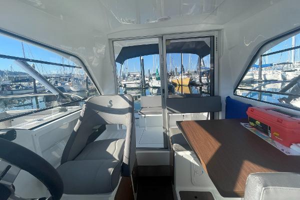 Slide: The Image of Interior of 2022 Beneteau Antares 7 boat with marina view through windows. - 11