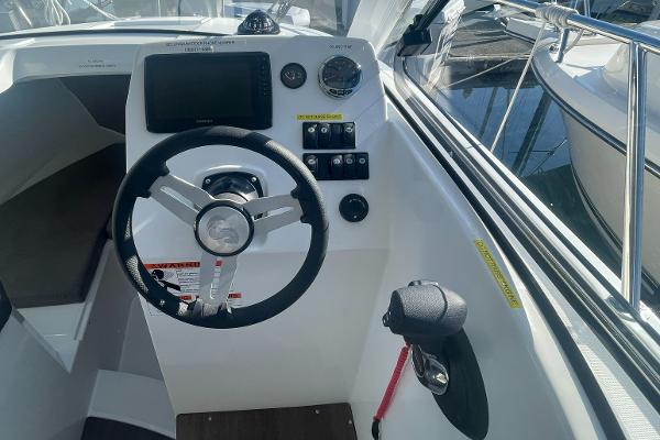 Slide: The Image of 2022 Beneteau Antares 7 helm station with steering wheel and navigation controls. - 12